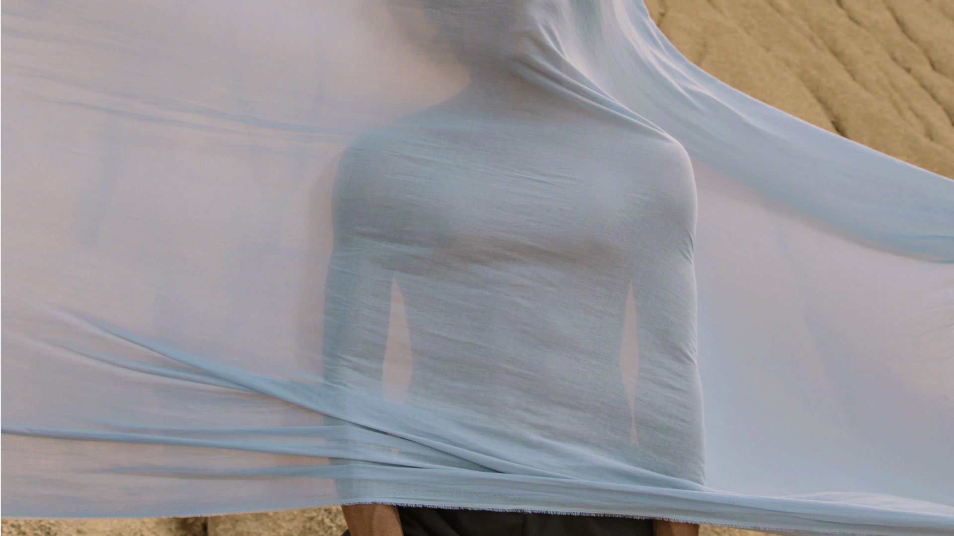 Person with bed sheets flying over them